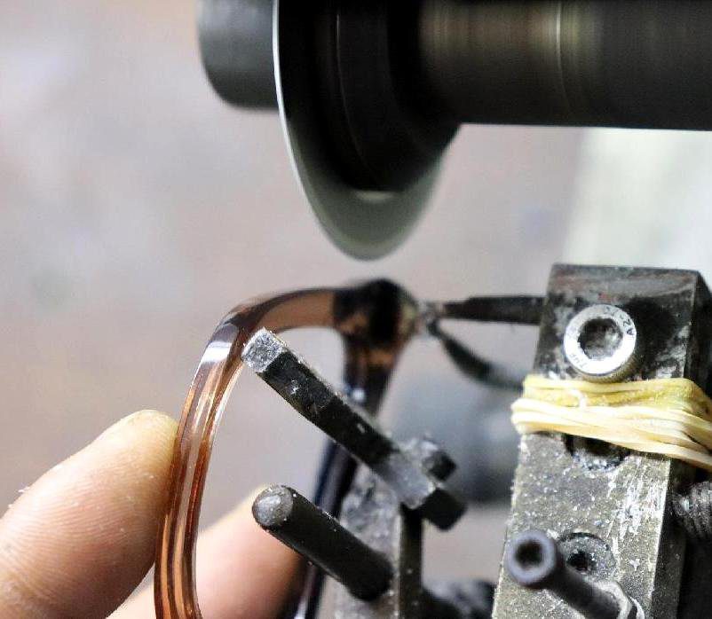 Frames mounted on a precision fixture for logo application — placement accuracy is controlled to fractions of a millimeter