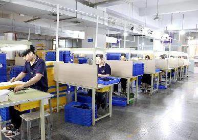Quality inspection on an eyewear production line — a dual-base factory runs identical QC standards in both countries