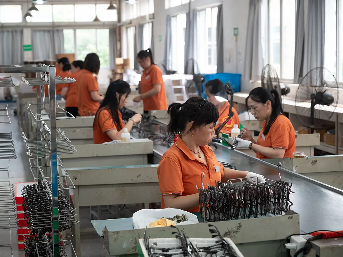 Worker performing final quality inspection on eyewear at Dongtian factory