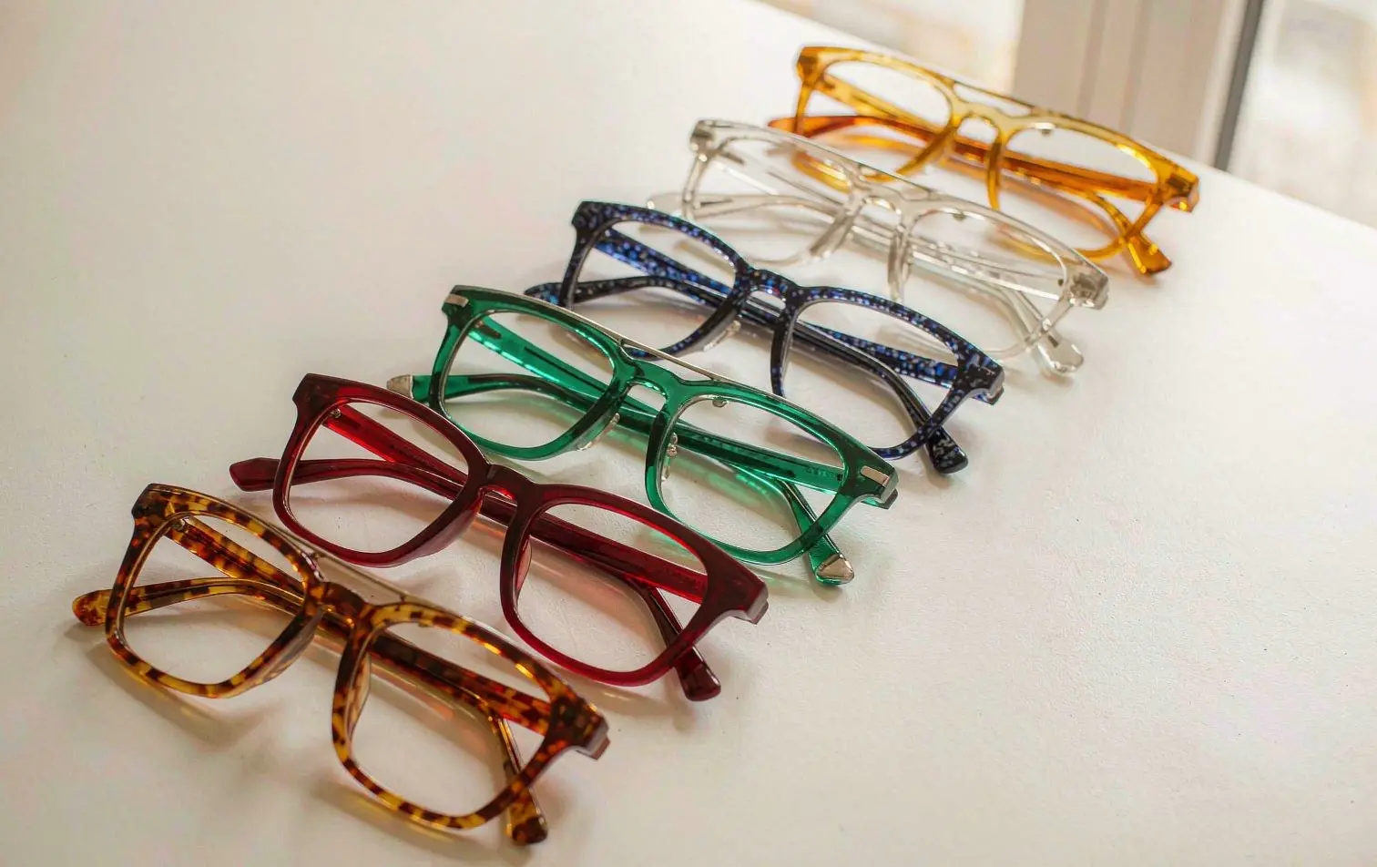 Colorful acetate optical frames flat lay on white desk - Dongtian eyewear
